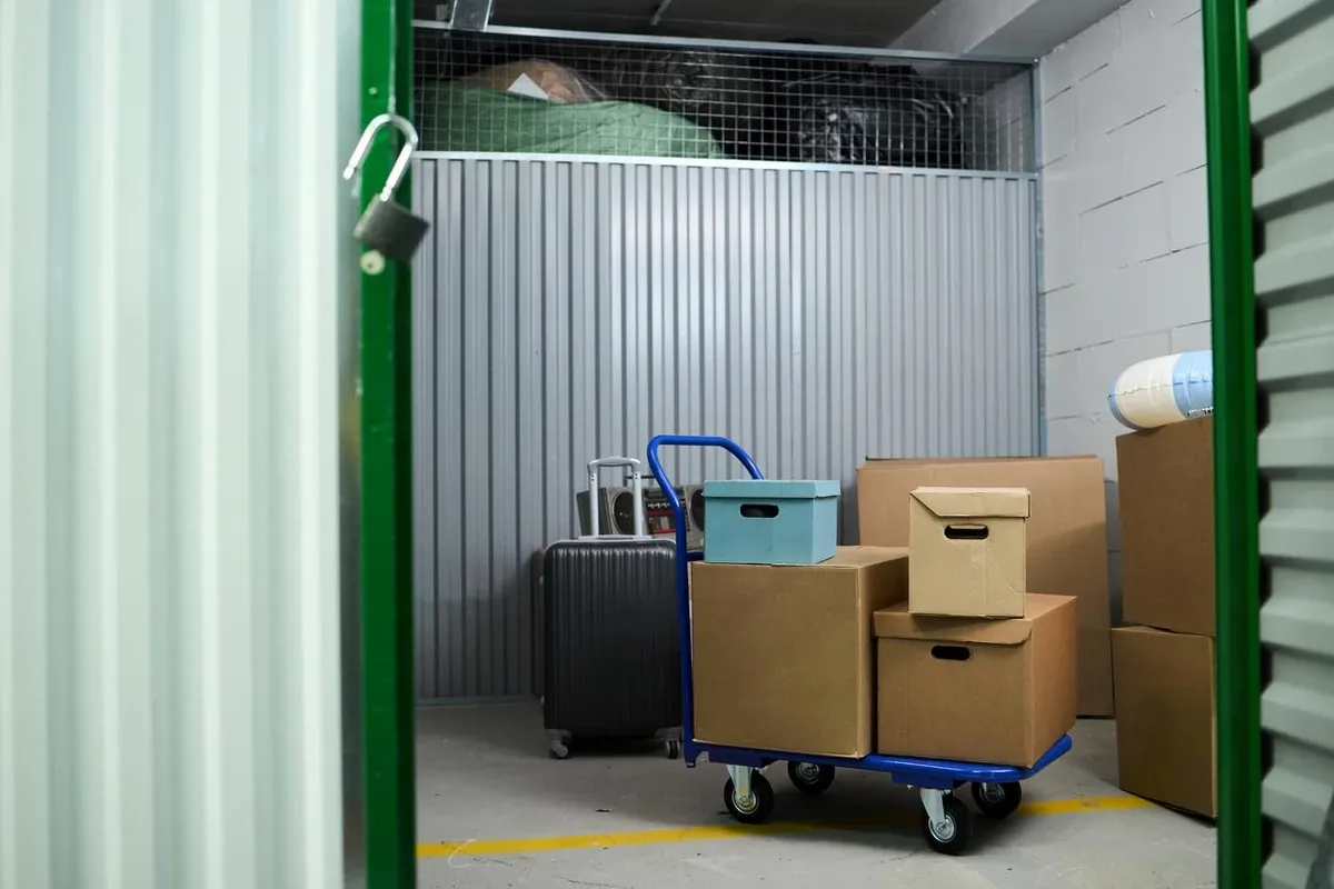 Open self-storage unit with a flatbed cart loaded with boxes.